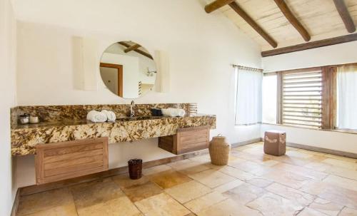 ein Badezimmer mit Waschbecken und Spiegel in der Unterkunft Tudo Bom Kitesurf Dream Villa in Taíba