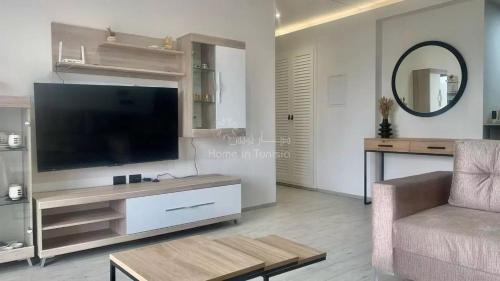 a living room with a television and a couch at seasonal rental S1 in Chott Meriem in Chott Meriem