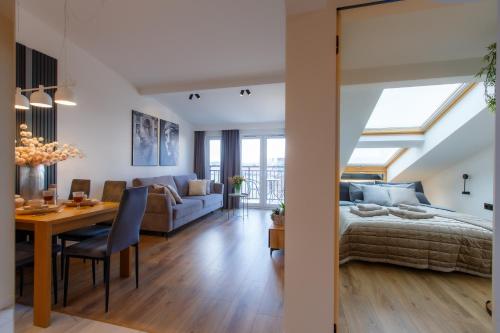 a bedroom and living room with a bed and a table at Apartamenty PREMIUM 56 obok Rynku Centrum, Parking - GARAŻ PODZIEMNY, wysoki standard, spokojna i cicha okolica, Parking - UNDERGROUND GARAGE, high standard, peaceful and quiet area in Kielce