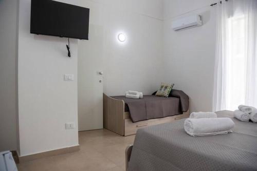 a room with a bed and a flat screen tv at Casa Ferrante in Cinisi