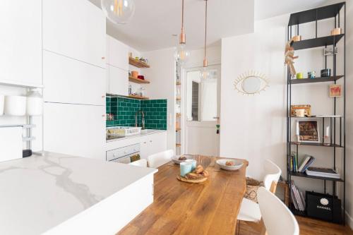 - une cuisine avec des murs blancs et une table en bois dans l'établissement GuestReady - Charming Central Apt near Les Halles, à Paris