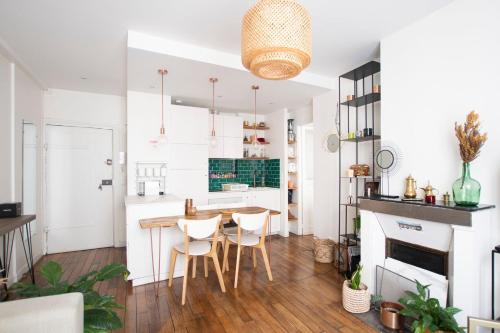 - une cuisine aux murs blancs avec une table et des chaises dans l'établissement GuestReady - Charming Central Apt near Les Halles, à Paris