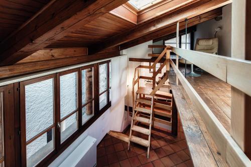 a room with a staircase in a house with windows at Casa Miró by Quokka 360 - in the village of Morcote in Morcote