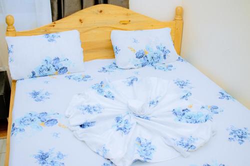 a bed with blue and white sheets and pillows at BC Empire Luxury Guest House in Kigali