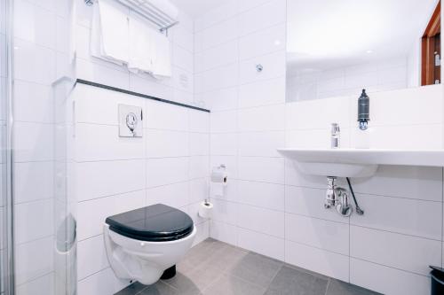 a white bathroom with a toilet and a sink at Best Western Plus JA Hotel Karlskrona in Karlskrona