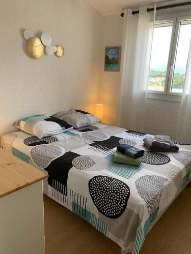 une chambre avec un lit avec une couette noire et blanche dans l'établissement Mas provençal proche St Tropez, à Cogolin