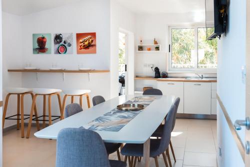 una cucina e una sala da pranzo con tavolo e sedie blu di Beautiful Terraced Villa City View by Arcobnb a Is-Swieqi