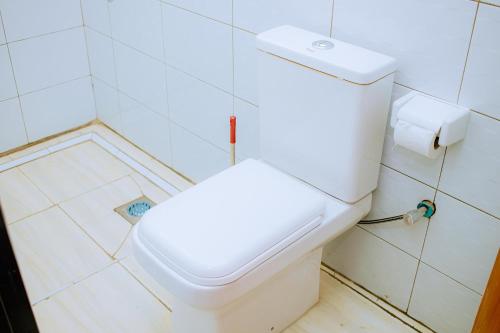 a bathroom with a white toilet in a room at BC Empire Luxury Guest House in Kigali