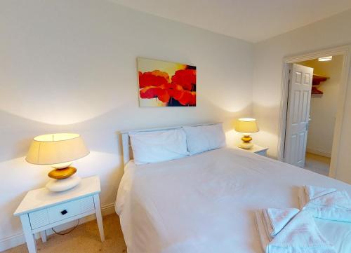 a bedroom with a white bed and two lamps at Lakeside Holiday Homes - Type A by Trident Holiday Homes in Killaloe