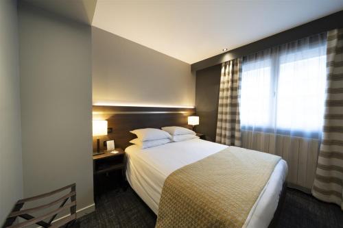 a hotel room with a bed and a window at Hôtel Bristol in Le Touquet-Paris-Plage