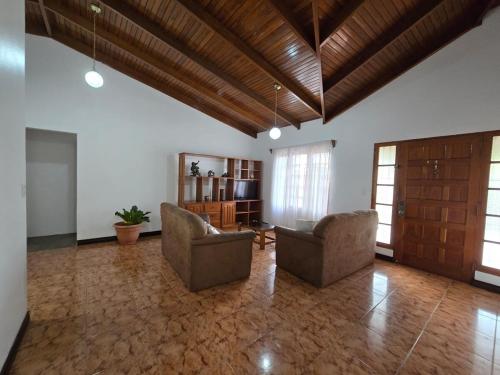 a large living room with two chairs and a television at Casa Rosabella in Ángeles