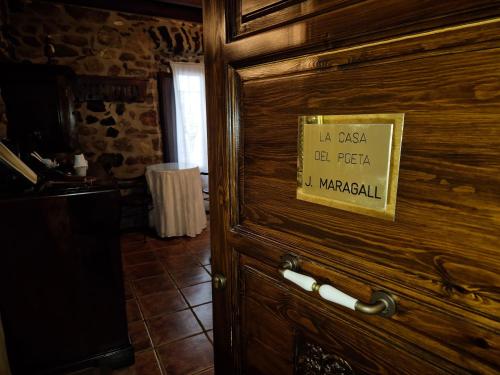 a wooden door with a sign on it at La Casa dels Poetes in Santa Pau