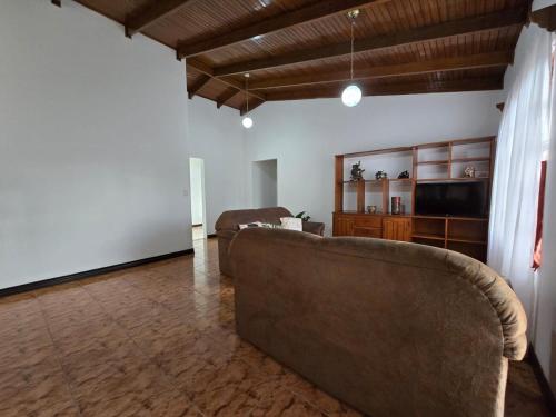 a living room with a couch and a television at Casa Rosabella in Ángeles