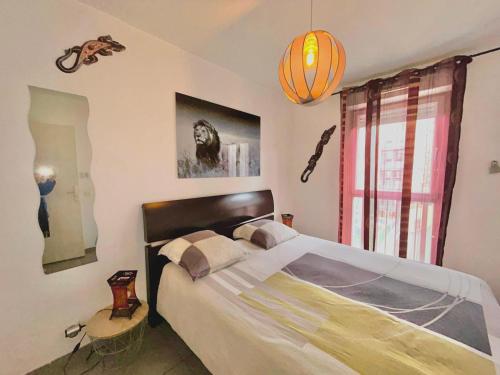 une chambre avec un grand lit et un lustre dans l'établissement Le 13OR - Appartement de charme en plein centre ville avec parking et jolie terrasse - Panier Joliette Vieux Port, à Marseille