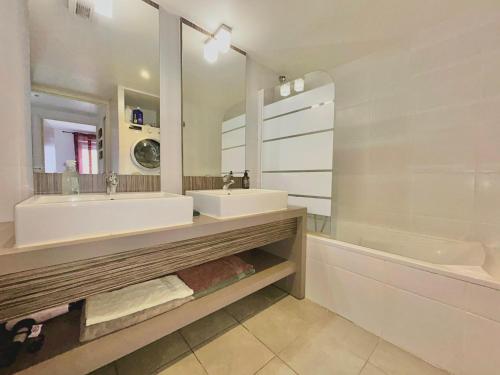 une salle de bain avec deux lavabos, une baignoire et un miroir dans l'établissement Le 13OR - Appartement de charme en plein centre ville avec parking et jolie terrasse - Panier Joliette Vieux Port, à Marseille
