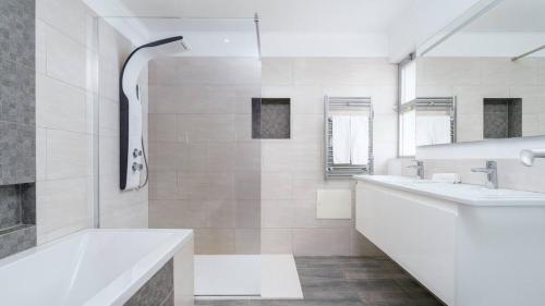 a white bathroom with two sinks and a tub at Villa Florida in Almancil