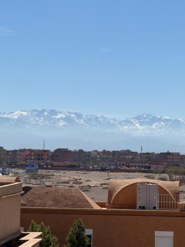 a view of a city with snow covered mountains at Maison Mamdy Rooftop in Marrakech