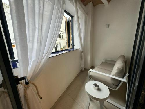 a small room with a chair and a window at Hotel Boutique Es Blau in Cadaqués