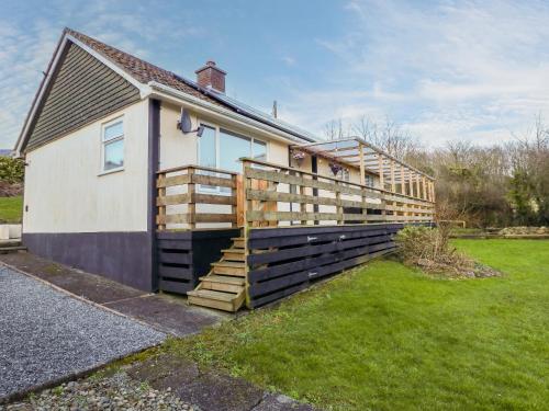a house with a wooden fence next to a yard at Petlyns Patch in Holyhead