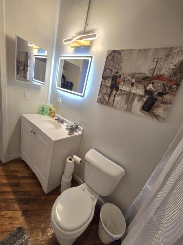 a bathroom with a white toilet and a sink at Detwah Downtown Studio Loft in Detroit