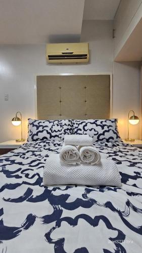 a bedroom with a large bed with a blue and white blanket at Your HOME away from home in Manila