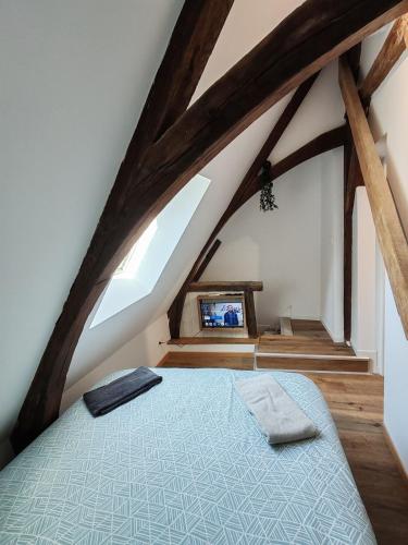 une chambre avec un lit dans un grenier dans l'établissement L'Hibou de la Cathédrale - Hyper Centre - Jardin - Wifi, à Troyes