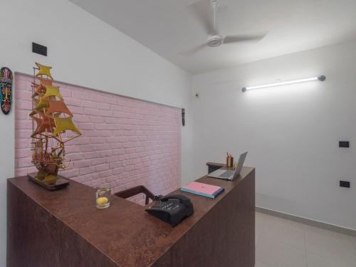 a room with a desk with a laptop on it at Daffodils by La Maison Charu in Puducherry