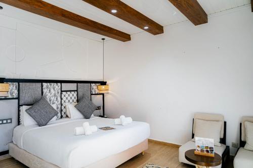 a bedroom with a large white bed and a chair at Hotel Dakhla Club & SPA in Dakhla