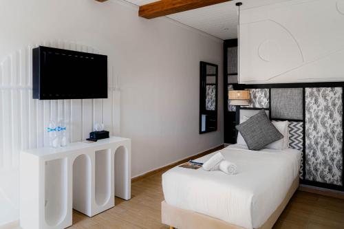 a living room with a white couch and a tv at Hotel Dakhla Club & SPA in Dakhla
