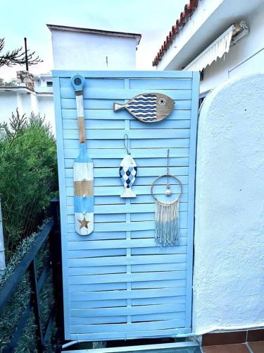 a blue door with decorations on the side of a house at B&P Miami playa Blue in Miami Platja