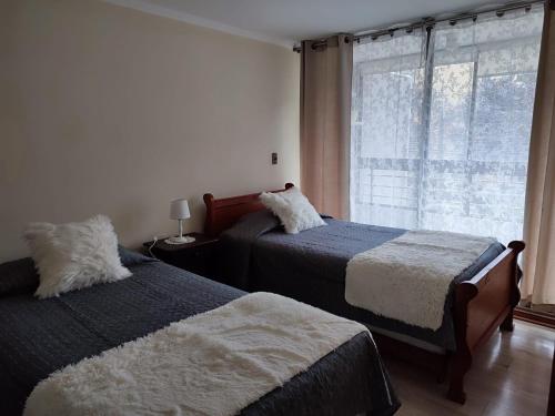 a bedroom with two beds and a window at FRONT Rioja in Viña del Mar