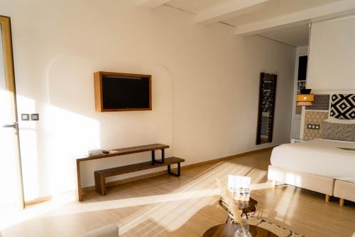 a bedroom with a bed and a tv on a wall at Hotel Dakhla Club & SPA in Dakhla