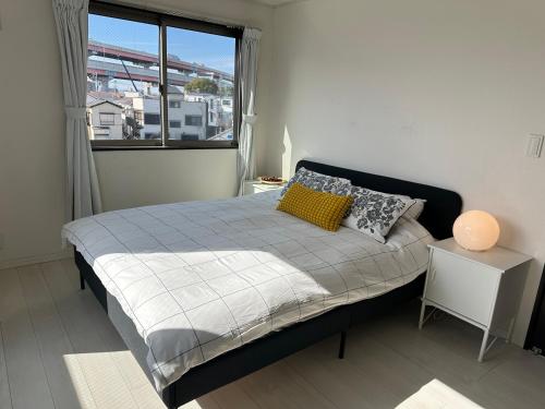 - une petite chambre avec un lit et une fenêtre dans l'établissement Mark的足立江北站民宿, à Tokyo