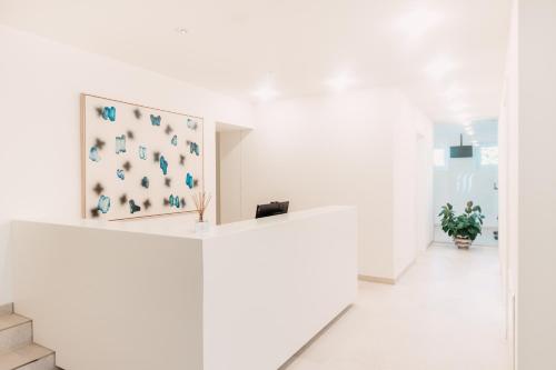 a white hallway with a white wall with a painting on it at Seehotel Dr. Jilly in Pörtschach am Wörthersee