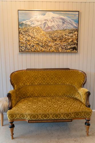 a couch in a room with a painting on the wall at Grund Cabin in Hvolsvöllur