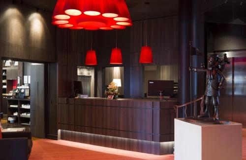 a statue of a man standing in front of a counter with red lights at Hôtel Bristol in Le Touquet-Paris-Plage
