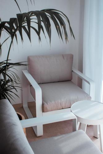 a white bench in a living room with a plant at Hotel Boutique Es Blau in Cadaqués
