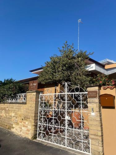 a fence with a gate in front of a building at Le Ninfe Guest House in Cisterna di Latina