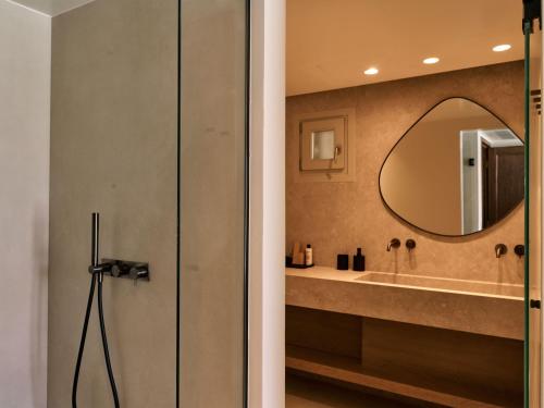 a bathroom with a shower and a mirror at Mykonos Rocks Villas & Suites in Mýkonos City