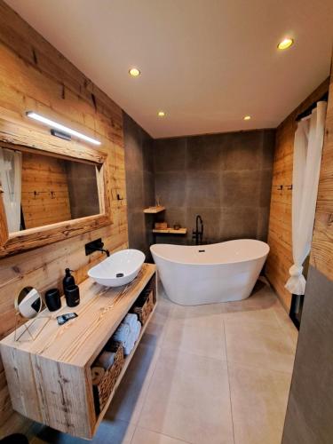 a bathroom with a large tub and a white sink at Hotel Kouty - Lesní Apartmány in Ledeč nad Sázavou