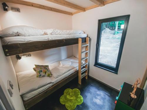 a room with two bunk beds and a window at Hotel Kouty - Lesní Apartmány in Ledeč nad Sázavou