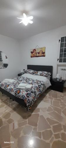 a bedroom with a bed with a comforter on it at Villa Marta la staccionata in Polignano a Mare