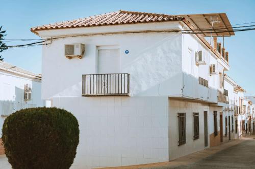 a white building with a balcony on a street at Arcadia Centro de Andalucía in Encinas Reales