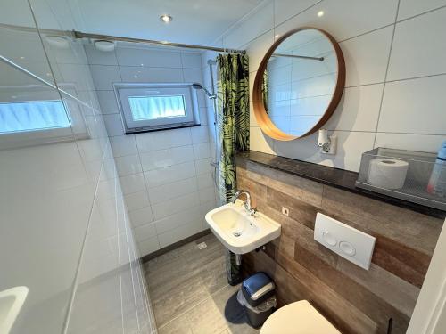 ein Badezimmer mit Waschbecken und Spiegel in der Unterkunft Bungalowpark Simpelveld - Schakel 22 in Simpelveld