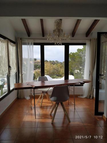 a dining room with a table and a large window at El Vaixell in Sant Josep de Sa Talaia