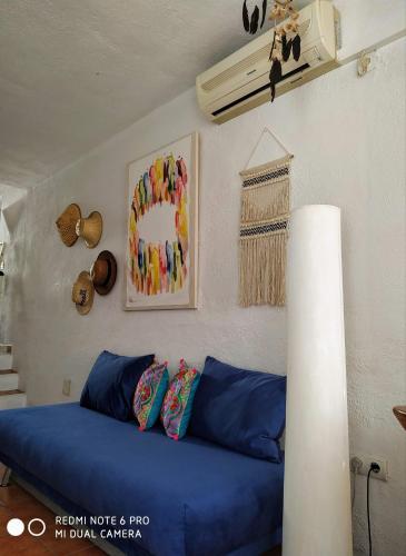 a living room with a blue couch and a fan at El Vaixell in Sant Josep de Sa Talaia