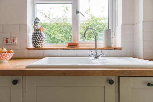 a kitchen counter with a sink and a window at Seafarer by Keepers Cottages in Kingsdown