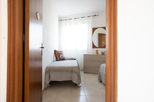 a small bedroom with a bed and a window at Sa Domo 'e Giosso in Flussio