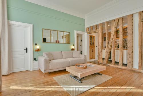 un salon avec un canapé et une table basse dans l'établissement Le Pianiste, en hypercentre avec balcon, à Limoges