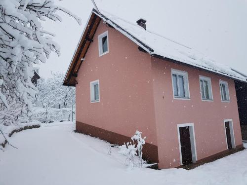 una casa roja con nieve en el techo en Ferienhaus Für 4 Personen Ca 65 M Sup2 In Brod Moravice, Gespanschaft Primorje Gorski Gorski Kotar, en Brod Moravice